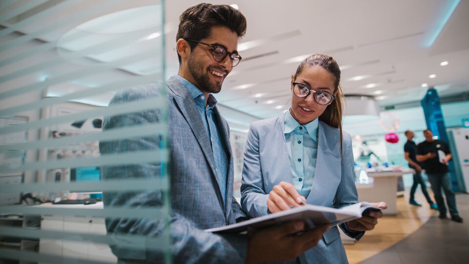 retail services consultant discussing store operations with a store manager in a high-end electronics store