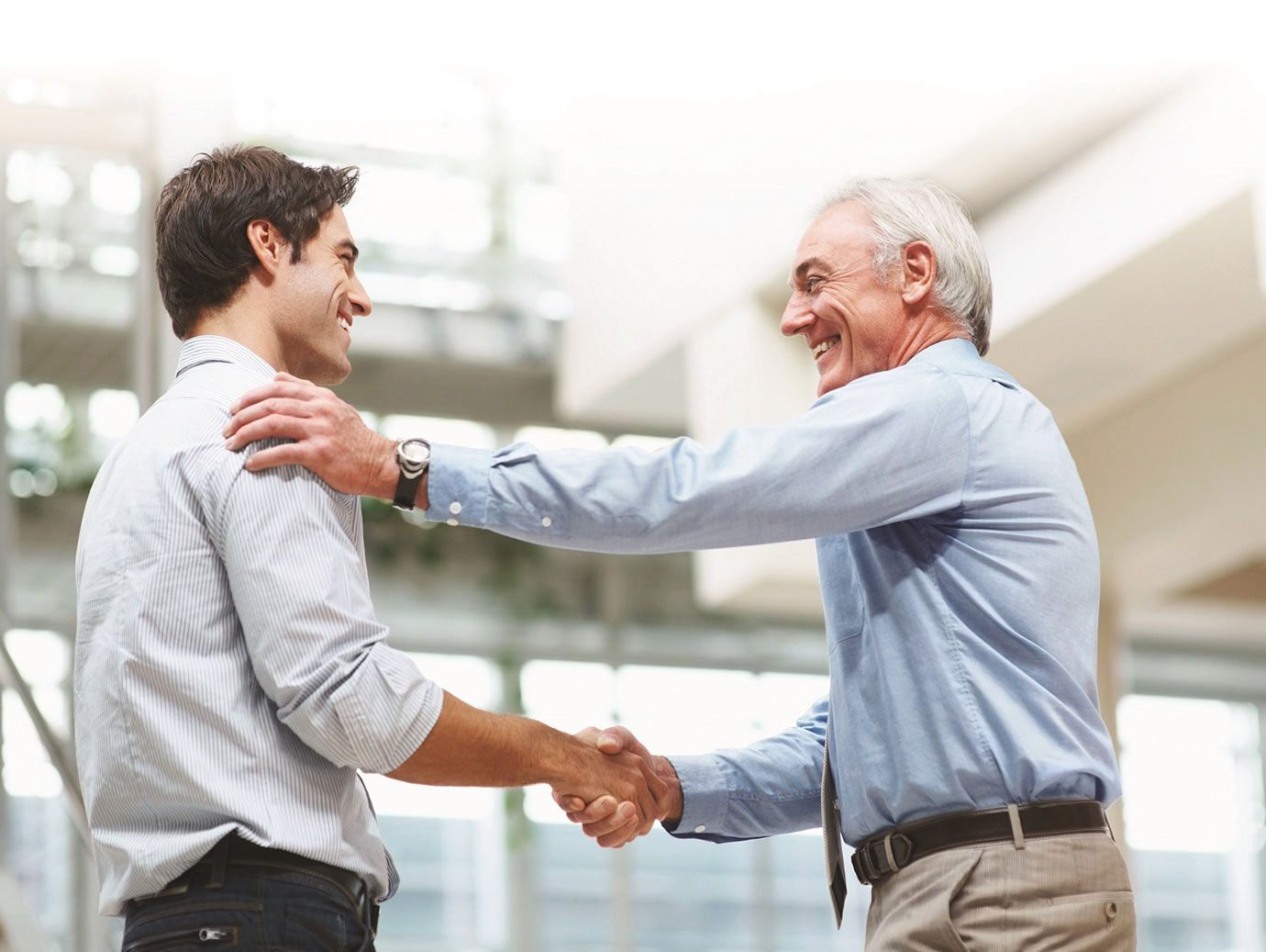 two professionals smiling with handshake