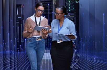 Two female colleagues disccusing work over a tablet in a data center