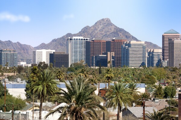 Group of high-rise commercial buildings surrounded by hills and palm trees