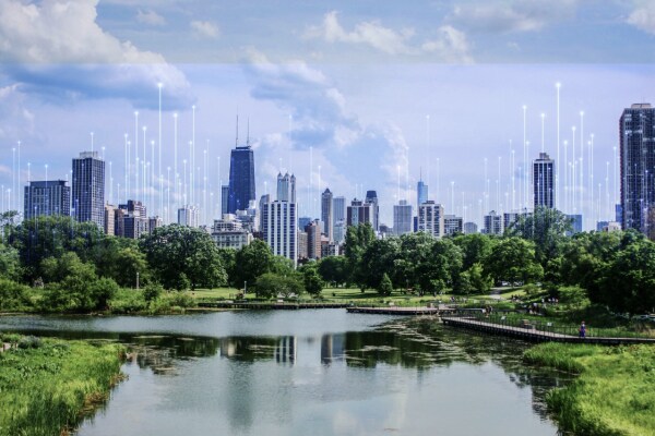 An urban skyline on the banks of a water body, with OpenBlue graphics in the background