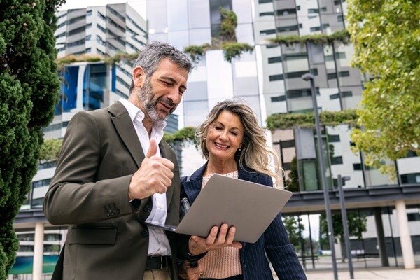 A man and women looking at laptop and discussing