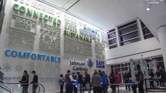 Interior of a Johnson Controls office, with people walking and going up an escalator